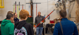 A male WPS employee demonstrates the tools and equipment used to deliver electricity inside a large learning lab