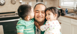 father hugging children